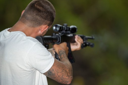 Rimfire shooter fires .22lr ammo Rimfire shooter takes aim at targets in a forest.